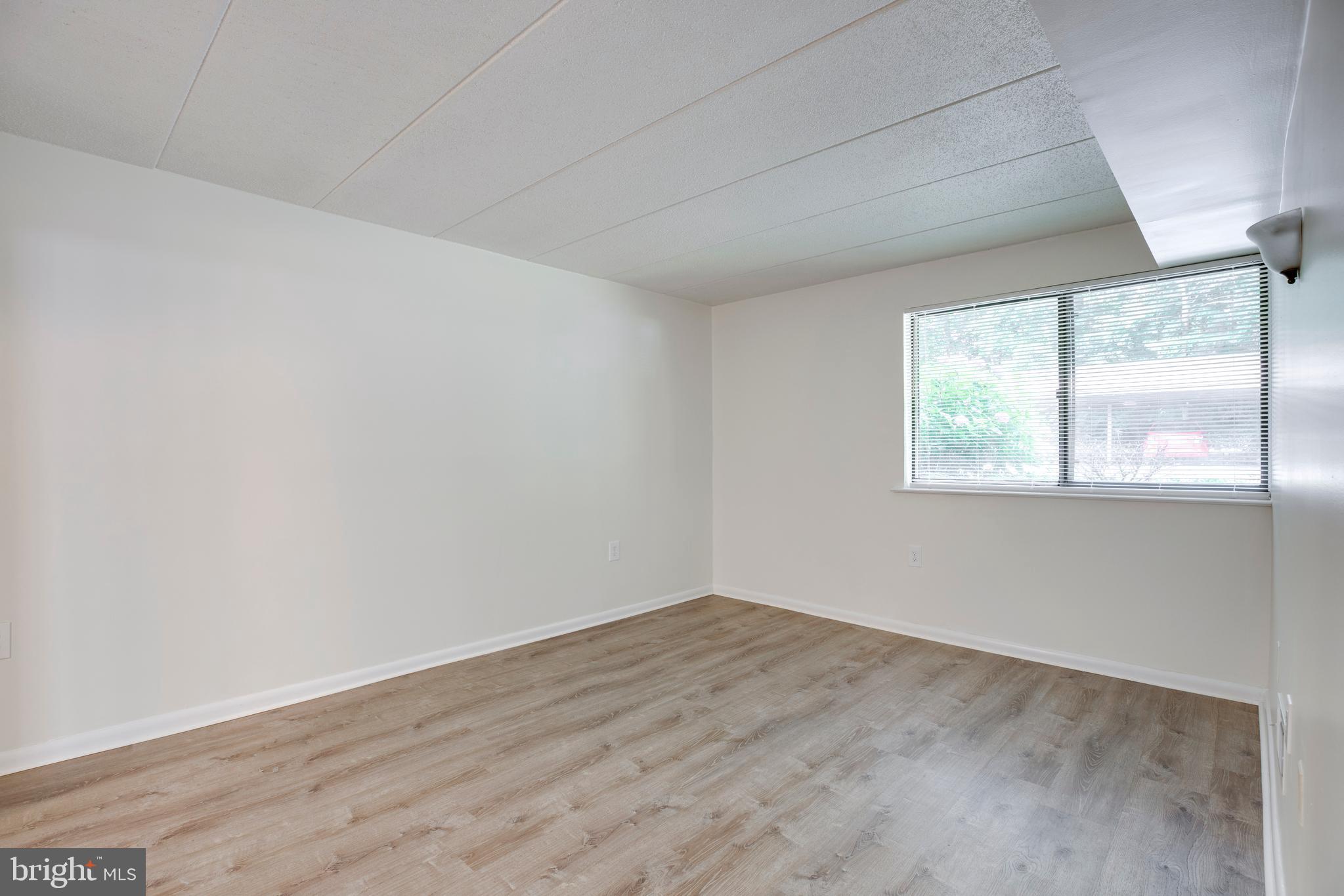 2106 Green Watch Way, Unit 101 Reston, VA 20191 - Photo 28 of 40 an empty room with wooden floor and windows