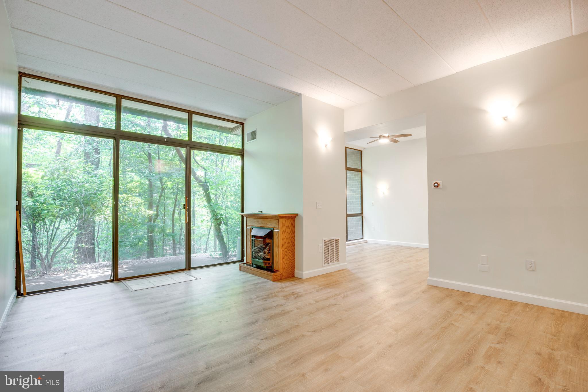 2106 Green Watch Way, Unit 101 Reston, VA 20191 - Photo 8 of 40 a view of an empty room with wooden floor and a window