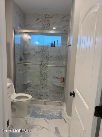 a bathroom with a granite countertop sink mirror vanity and toilet