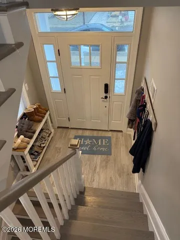 a view of entryway and hall with wooden floor