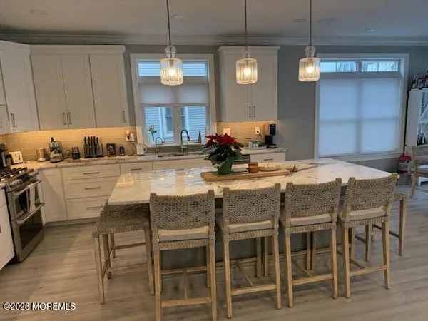 a kitchen with granite countertop a refrigerator a stove a sink dishwasher and wooden cabinets with wooden floor