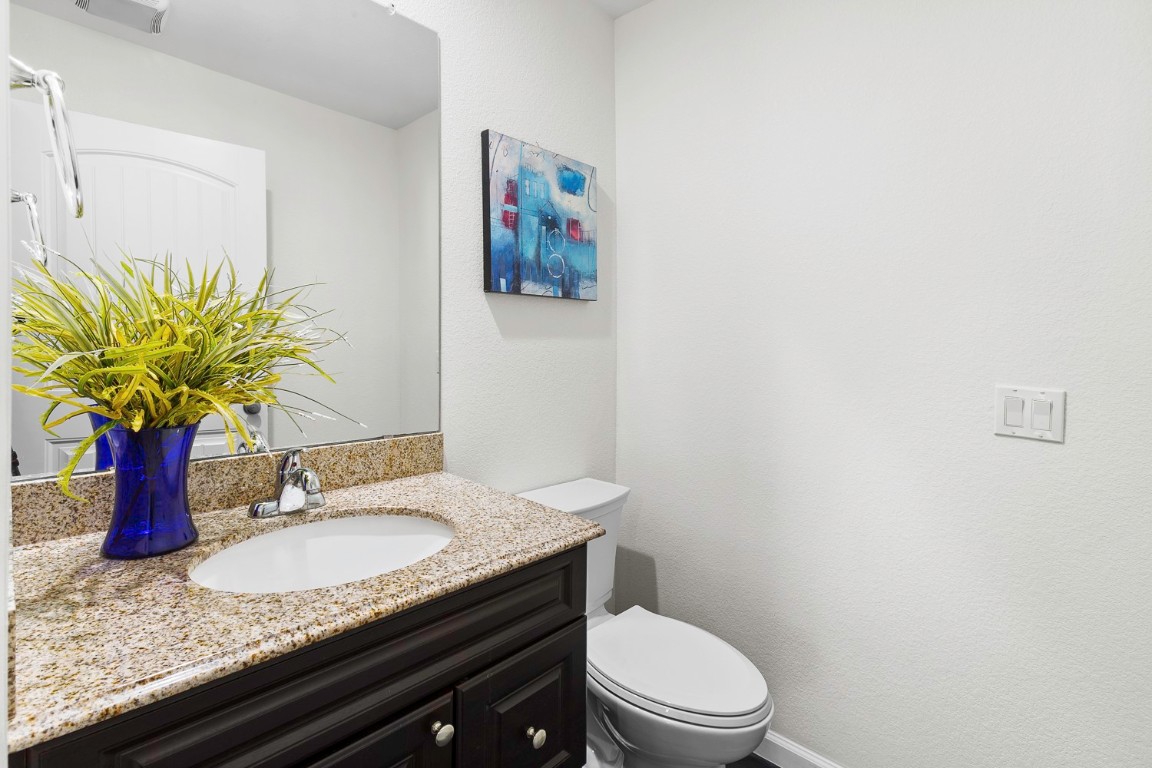 11221 Mickelson Drive Austin, TX 78747 - Photo 10 of 28 a bathroom with a granite countertop toilet sink and mirror