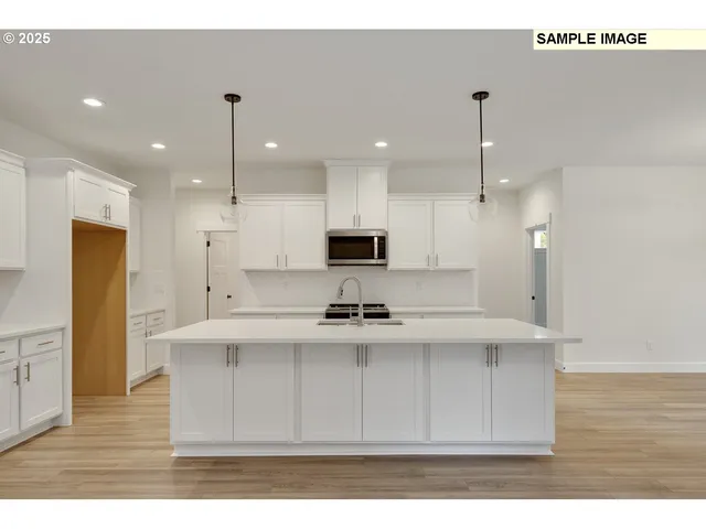 a kitchen with kitchen island stainless steel appliances a sink a stove a refrigerator and cabinets