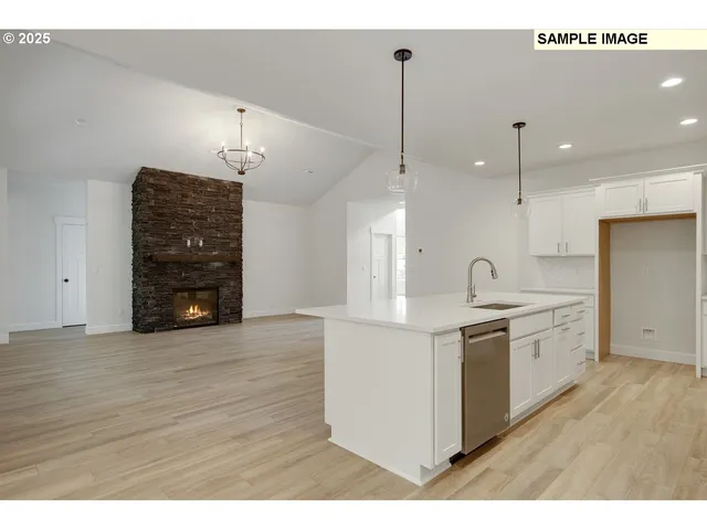 a kitchen with stainless steel appliances granite countertop a sink a stove and a wooden floors