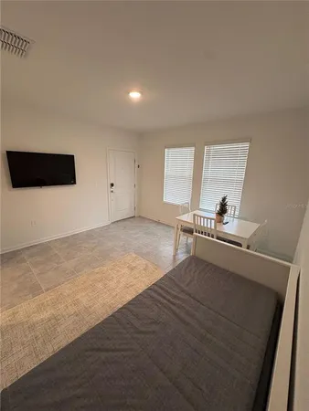 a living room with a bed furniture and a flat screen tv