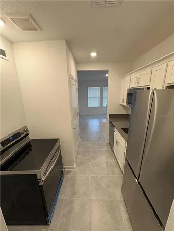 a kitchen with a refrigerator and a stove