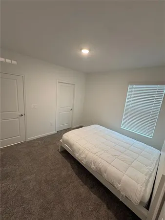 a bed sitting in a bedroom next to a window