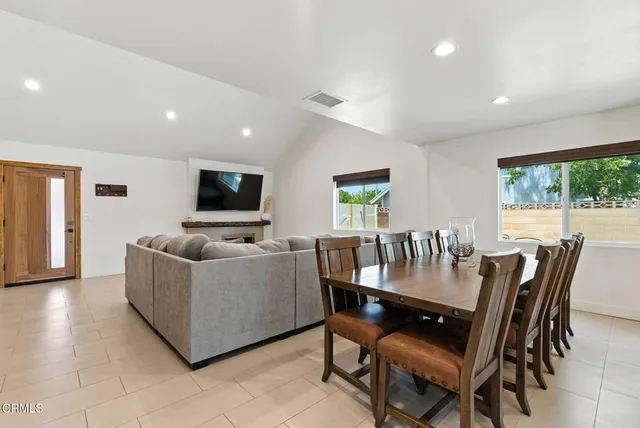 a living room with furniture a flat screen tv and a floor to ceiling window