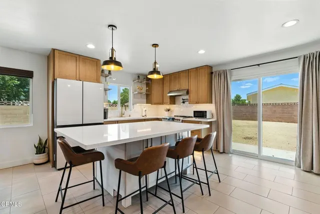 a kitchen with kitchen island a large window and cabinets