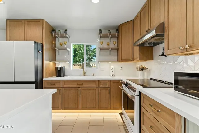 a kitchen with a sink a refrigerator and cabinets