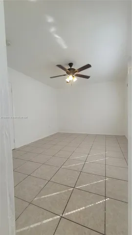 a view of a room with an empty space and a ceiling fan