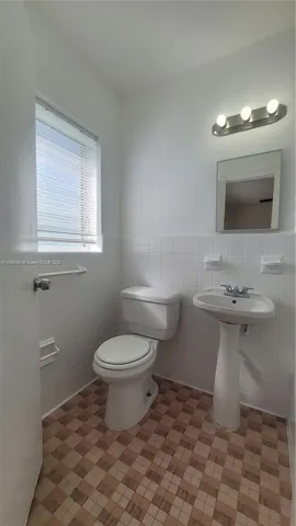 a bathroom with a sink toilet and mirror