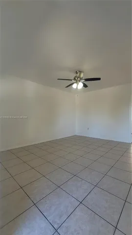 a view of a room with an empty space and a ceiling fan