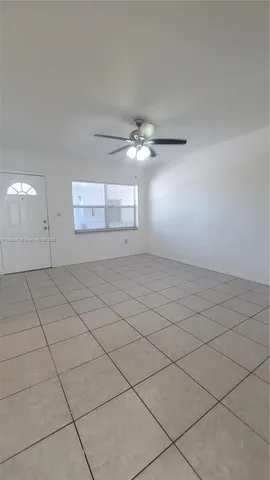an empty room with windows and ceiling fan