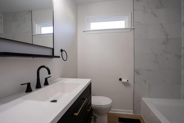 a bathroom with a sink toilet and a mirror
