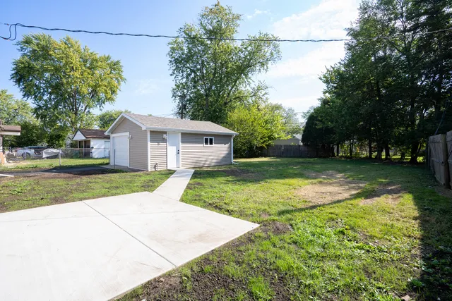 a view of a house with backyard and trees