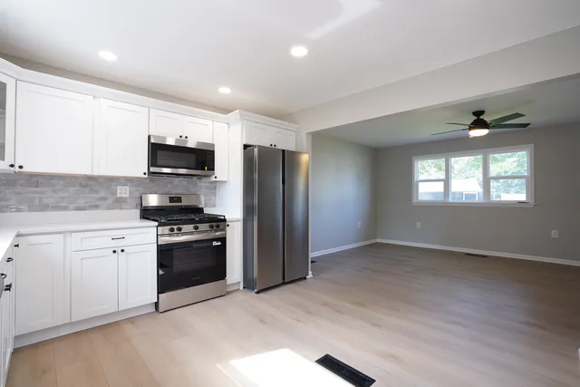 a kitchen with stainless steel appliances granite countertop a stove a sink and a refrigerator