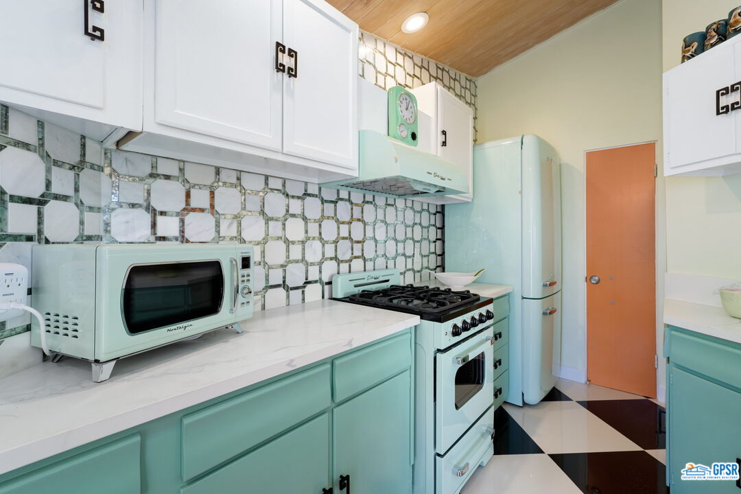 37800 Da Vall Drive, Unit 9 Rancho Mirage, CA 92270 - Photo 16 of 24 a kitchen with stainless steel appliances a stove a microwave a sink and cabinets