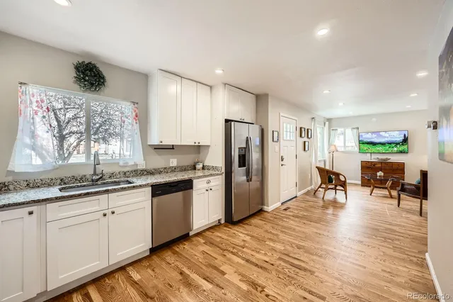a kitchen with stainless steel appliances granite countertop a refrigerator and a stove top oven