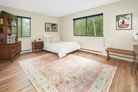 a spacious bedroom with a bed and wooden floor