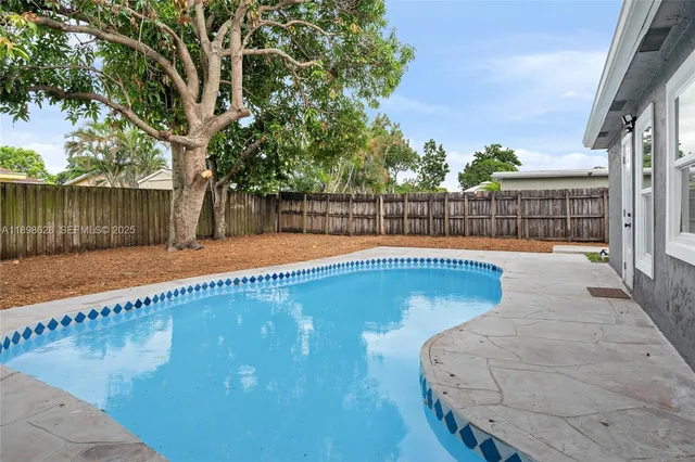 a view of swimming pool with a patio and wooden fence