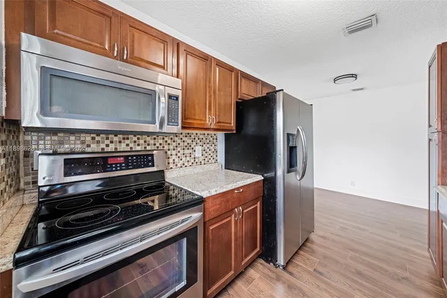a kitchen with wooden cabinets and a stove top oven