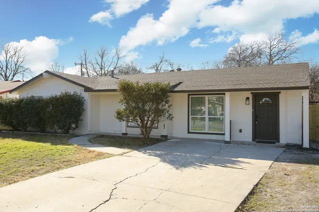 a front view of a house with a garden and plants