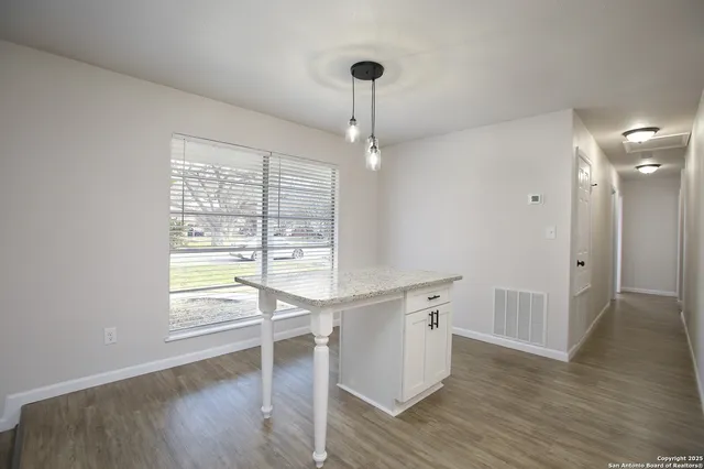 a room with wooden floor and windows