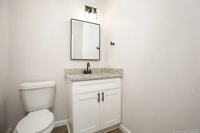 a bathroom with a toilet sink and mirror