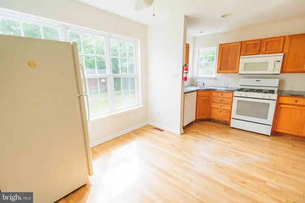 a view of a kitchen with wooden floor and electronic appliances
