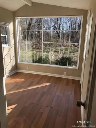 a view of a room with wooden floor and windows
