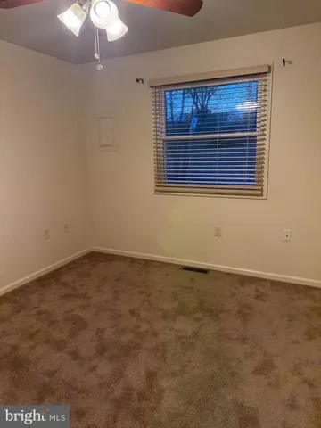 an empty room with a chandelier fan