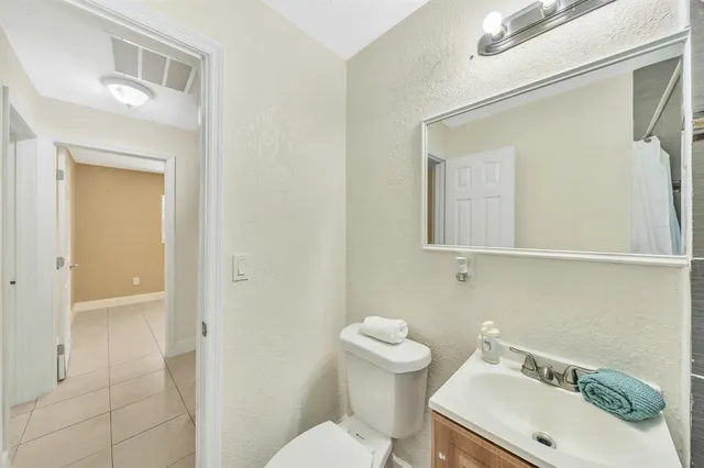 a bathroom with a sink mirror and toilet