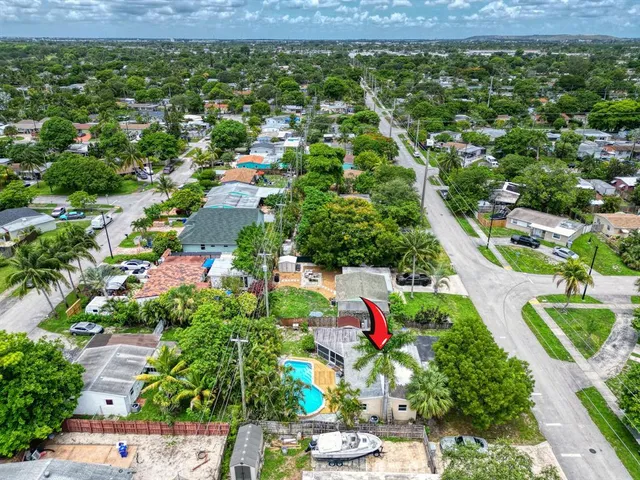 an aerial view of residential houses with outdoor space and trees