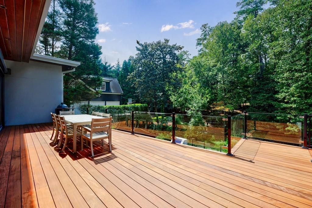 4036 Statewood Road Northeast Atlanta, GA 30342 - Photo 27 of 84 a view of a roof deck with table and chairs with wooden floor and fence