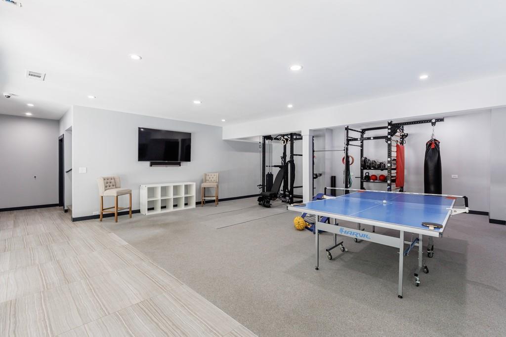 4036 Statewood Road Northeast Atlanta, GA 30342 - Photo 58 of 84 a view of a room with gym equipment and a flat screen tv