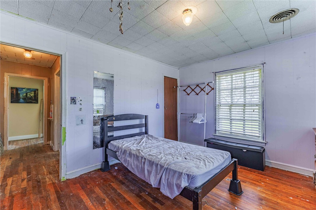 3840 Parrish Street Waco, TX 76705 - Photo 15 of 17 a bedroom with a bed and wooden floor