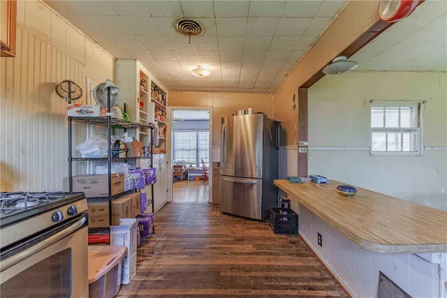 a kitchen with stainless steel appliances granite countertop a refrigerator a stove and a wooden floors