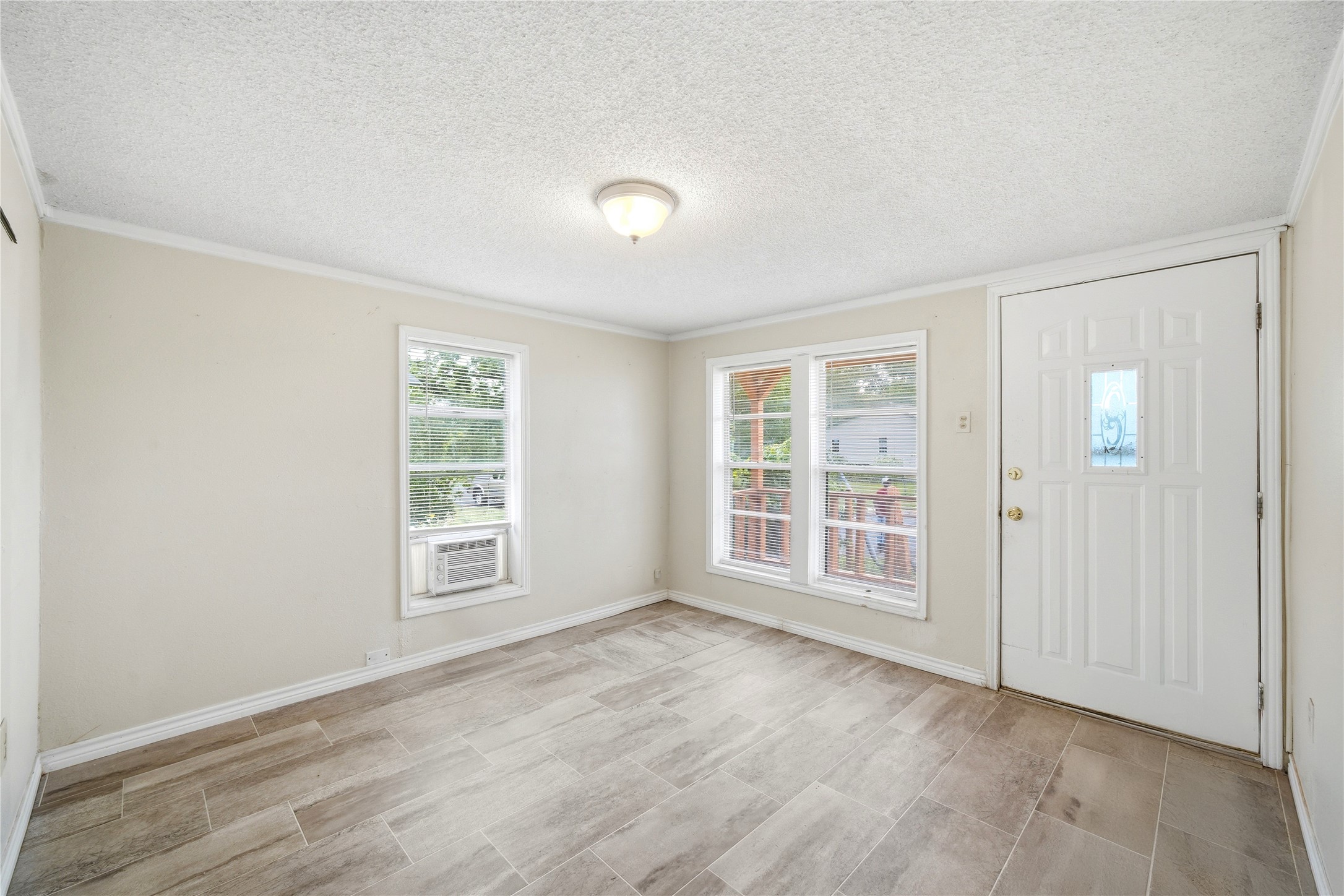 101 Outlar Street Wharton, TX 77488 - Photo 4 of 40 an empty room with wooden floor and windows