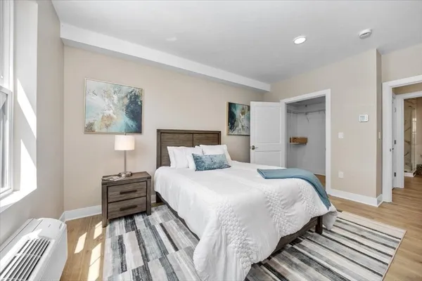 a bedroom with a bed and a painting on the wall