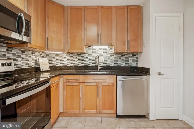 a kitchen with stainless steel appliances granite countertop a stove and a microwave