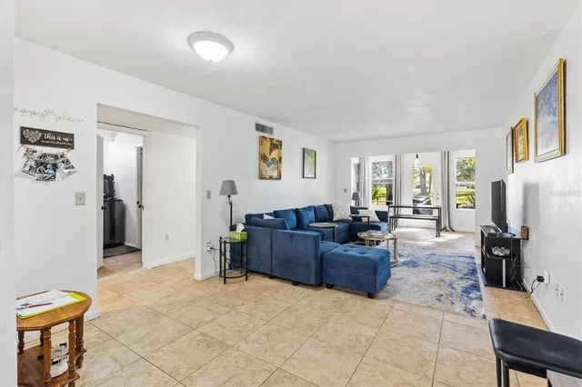 a living room with furniture and a refrigerator