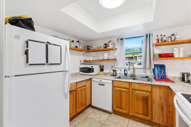 a kitchen with appliances a sink and a refrigerator
