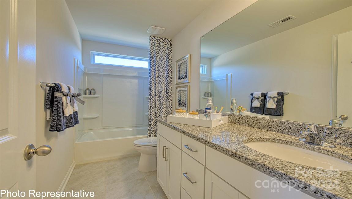 448 Wheatfield Road Fletcher, NC 28732 - Photo 42 of 47 a bathroom with a granite countertop sink a toilet a mirror and shower