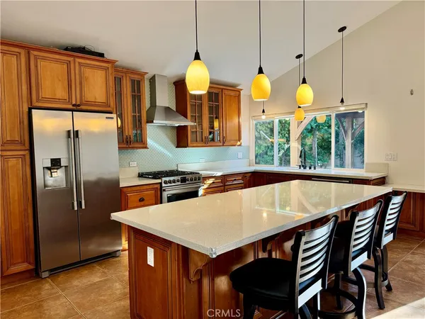 a kitchen with a table a refrigerator and wooden floor