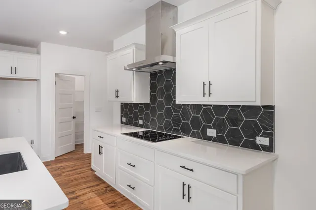 a kitchen with stainless steel appliances kitchen island a refrigerator sink and cabinets