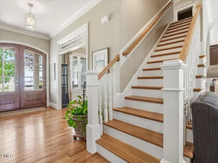 a view of a hallway with wooden floor and staircase