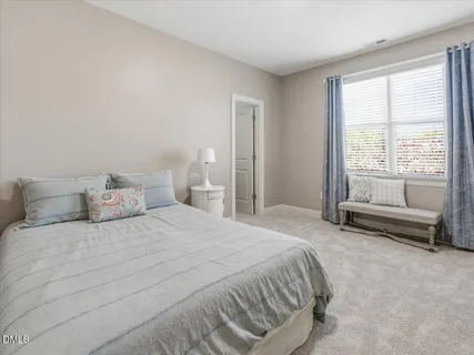 a bedroom with a bed chair and a window