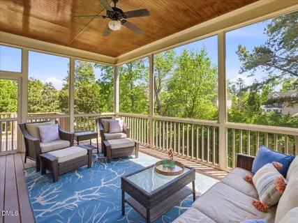 a view of a hallway to a livingroom with wooden floor and furniture
