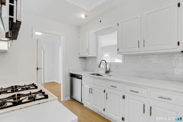 a kitchen with white cabinets and appliances